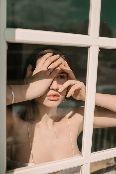 Kobieta Biustonosz Stojąc Przy Oknie Dotykania Twarzy Słoneczny Dzień — Zdjęcie stockowe
