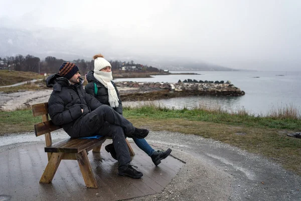 Tourists relaxing on bench on elevation by sea — Stock Photo, Image