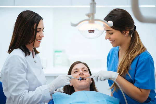 Zahnarzt und Assistent untersuchen Mund des Patienten im Stuhl mit Werkzeug — Stockfoto