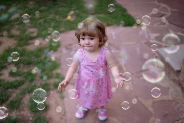 Adorable Child Pink Dress Laughing Capturing Rainbow Soap Bubbles Green — Stock Photo, Image