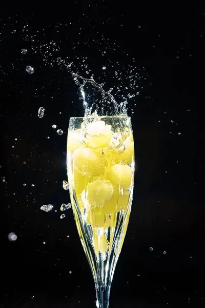 シャンパンのグラスに落ちるブドウ — ストック写真