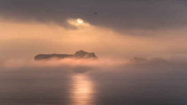 Spokojna Powierzchnia Oceanu Chropowaty Klif Pod Gęstą Mgłą Jasnym Słońcem — Zdjęcie stockowe