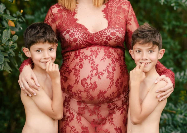 在花园里拥抱双胞胎男孩的孕妇 — 图库照片