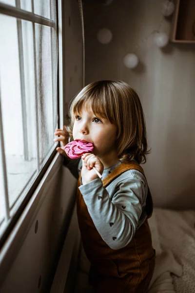 Schattig Klein Meisje Casual Kleding Zuigen Zoete Lolly Kijken Uit — Stockfoto