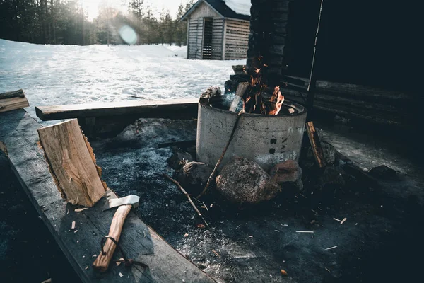 Brennendes Lagerfeuer Und Baumstamm Mit Axt Der Nähe Einer Holzfällerhütte — Stockfoto