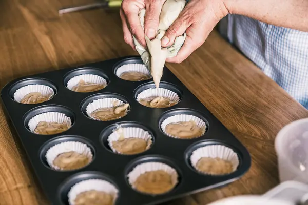 Góry Zboża Żeński Cukiernik Stojący Przy Stole Tacą Muffinki Wypełnienie — Zdjęcie stockowe