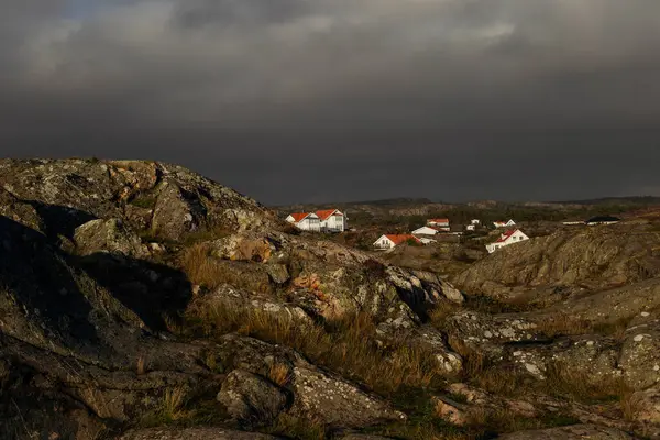 Rotsachtig Landschap Met Dorpshuizen Zonlicht Donkere Bewolkte Lucht — Stockfoto