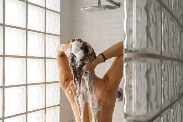 샤워실에 머리를 씻으면서 샴푸를 거품으로 만들고 알아볼 수없는 여성의 — 스톡 사진
