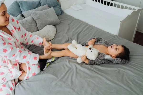 Yukardan Gelen Bornozlu Kadın Yumuşak Yatakta Küçük Çocukla Eğleniyor — Stok fotoğraf
