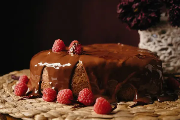 自家製のハート型のケーキをチョコレートトッピングと新鮮なラズベリーで食欲をそそります — ストック写真