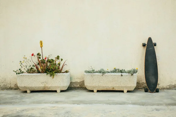 Monopatín apoyado contra la pared - foto de stock