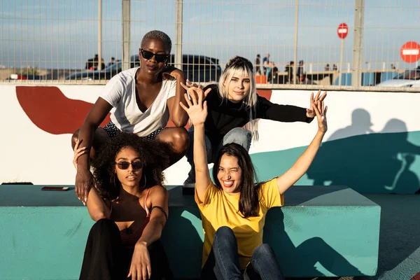 Cheerful young multiracial female friends enjoying free time in street — Stock Photo