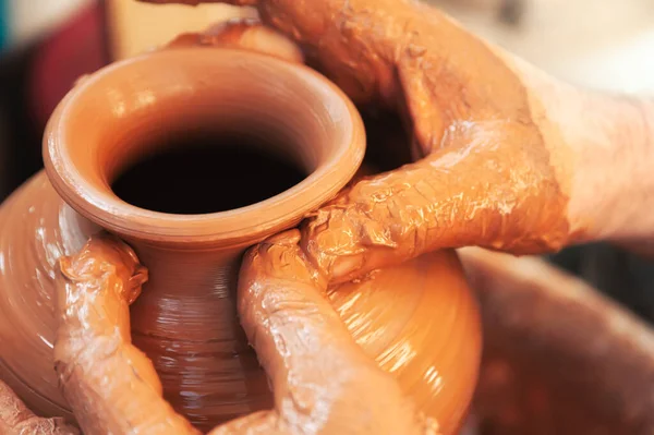Крупный план анонимный ремесленник, делающий вазу из глины во время работы в профессиональной керамике — стоковое фото