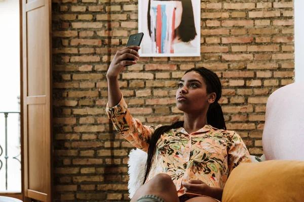 Jeune femme ethnique prenant selfie à la maison — Photo de stock
