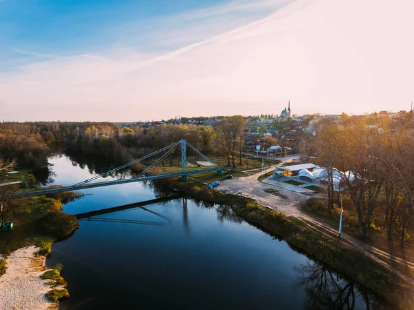 Altın kırmızı güneş ışığı hava görüntülemek, Rusya, nehir, küçük bir kasaba, köprü