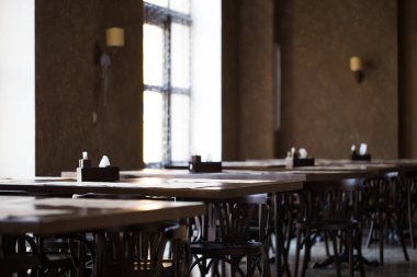 Antika bir kafe ya da restoran. Pencerenin karşısındaki tablolar.