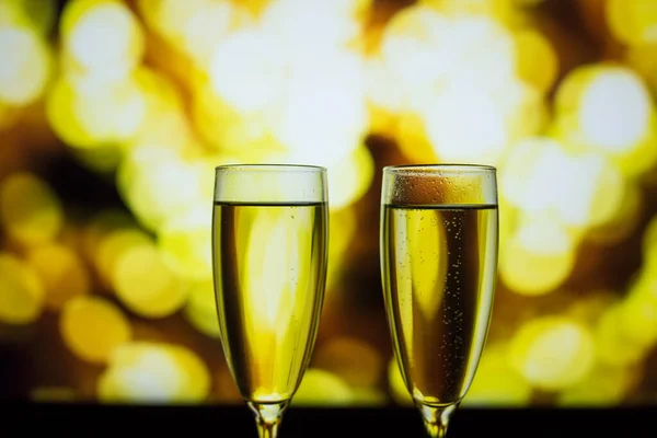 Twee glazen champagne op een bokeh achtergrond. Close-up geïsoleerde achtergrond. — Stockfoto