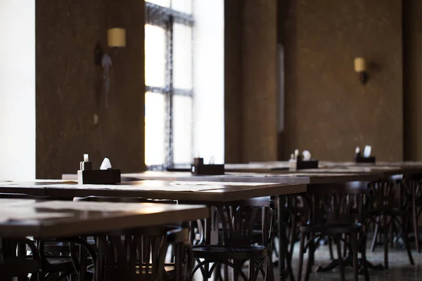Antika bir kafe ya da restoran. Pencerenin karşısındaki tablolar.
