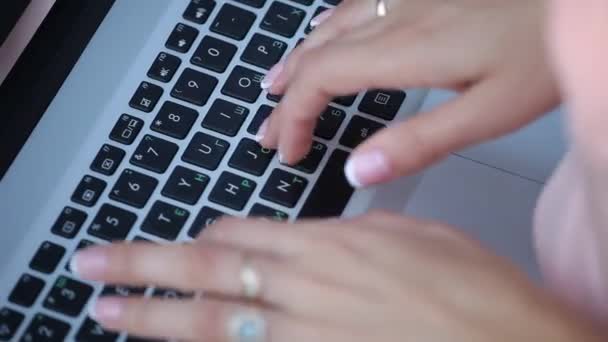Flickan skriver texten på den bärbara datorn. som en flicka med en fin manikyr — Stockvideo