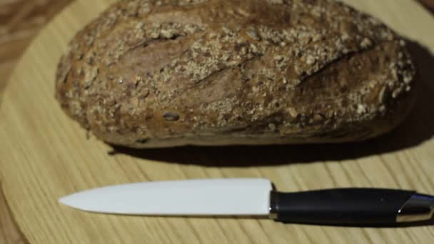 On Top of Bread Sprinkled With Seeds. Bread Turns on a Tray. at the Bread Knife is Great. — Stock Video