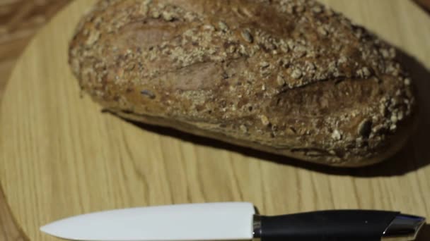 Coltello da pane tagliente. L'uomo prende un coltello e inizia a tagliare il pane . — Video Stock