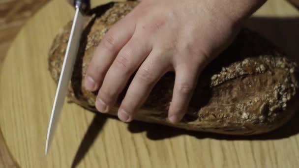 Eine Person schnitt Brot akut naamah. Brot liegt auf einem großen runden Tablett. wenn ein Mann, der Brotblech schneidet, dann losrennt — Stockvideo