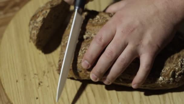 Eine Person schnitt Brot akut naamah. Brot liegt auf einem großen runden Tablett. wenn ein Mann, der Brotblech schneidet, dann losrennt. — Stockvideo