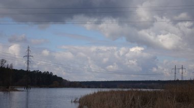 Nehir üzerinde uzun boylu kuru ot büyümek. Nehri profili bulutlu hava.