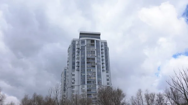 Maison haute. Vue du bâtiment de bas en haut. Au-dessus de la maison flottant épais nuages gris — Photo