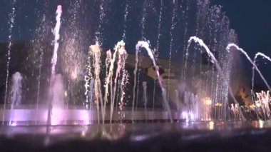 Gece-zaman şehir merkezinde çeşme. Su sonra tekrar falls yükselir. Çeşme ışıklar Parlatıcı farklı renklerde alt kısmında.