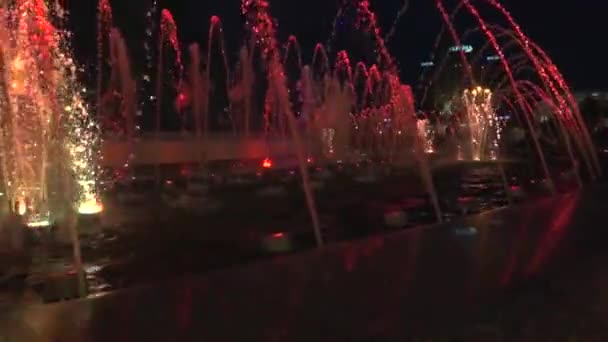 Fontana di notte in centro. Lenta acqua video poi si alza di nuovo cade. Nella parte inferiore della fontana le luci brillano in diversi colori . — Video Stock