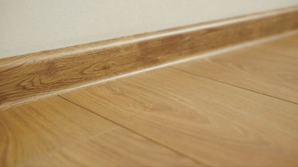 The camera moves along the floor, covered with laminated parquet with a brown wooden texture — Stock Footage The camera moves along the floor, covered with laminated parquet with a brown wooden texture Royalty Free Stock Footage