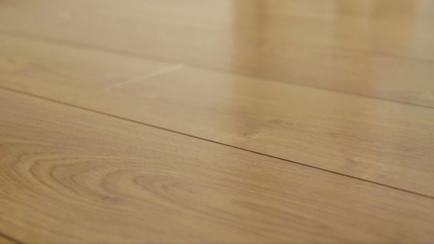 The camera moves along the floor, covered with laminated parquet with a brown wooden texture — Stock Footage The camera moves along the floor, covered with laminated parquet with a brown wooden texture Royalty Free Stock Footage