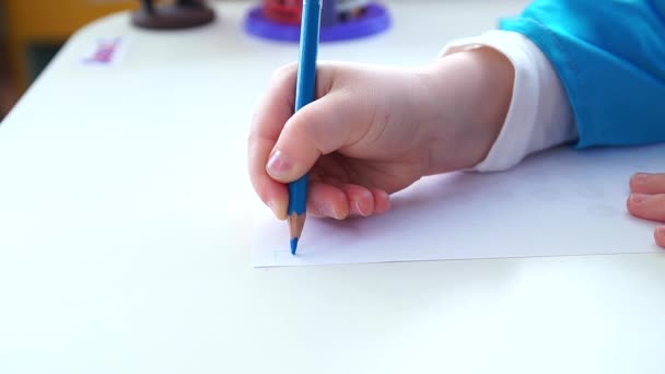 Het kind schrijft de letter op papier. — Stockvideo