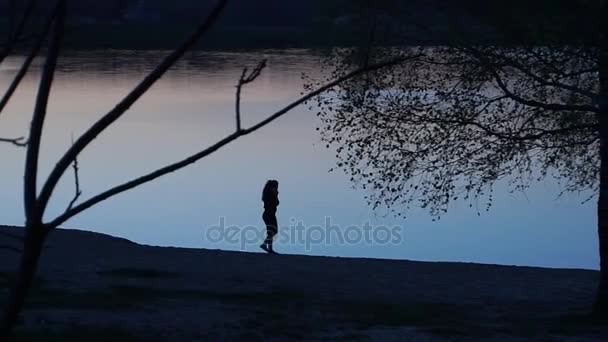 Meisje in de buurt van lake in de avond. — Stockvideo