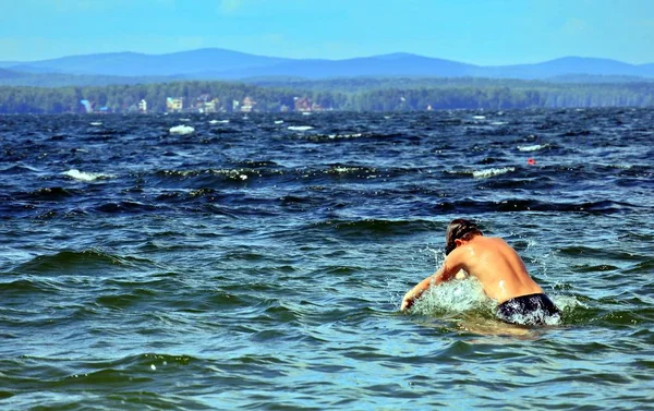 Young boy jumping into lake