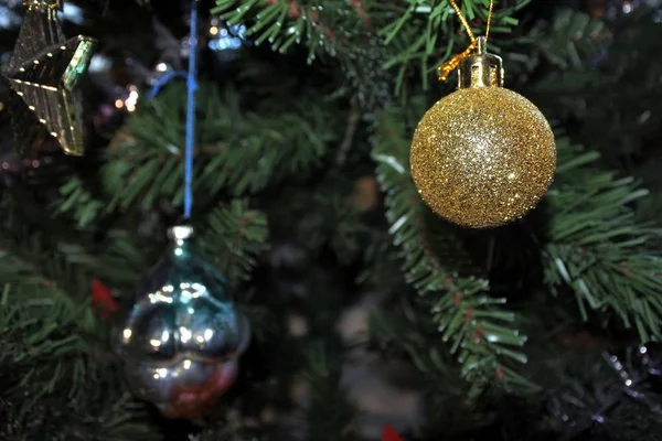 Golden ball. christmas toys on new year tree background. — Stock Photo, Image