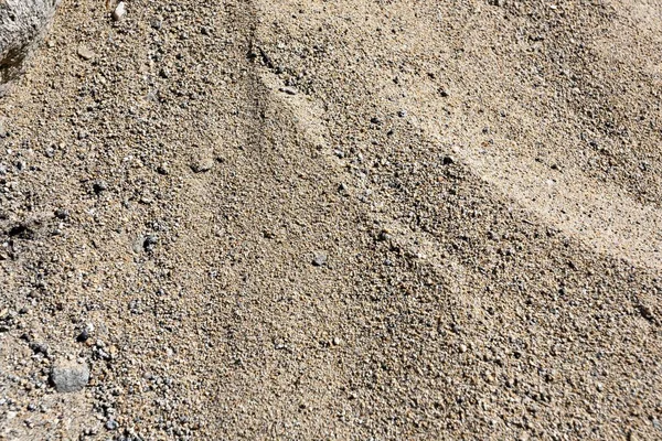 A textura da areia sob os raios diretos do sol no lago — Fotografia de Stock