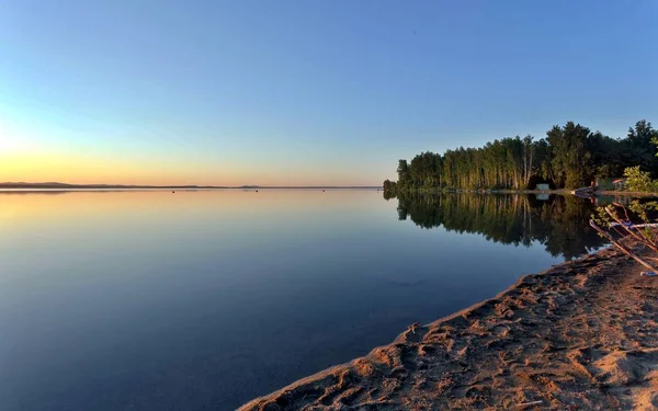 Golden sun sinks over the lake in the evening — Stock Photo, Image