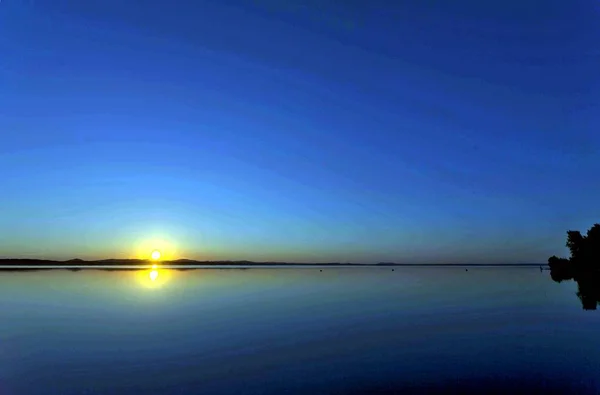 金色的太阳在傍晚的湖面上下沉 — 图库照片