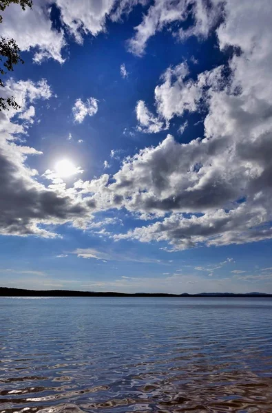 Langit biru terang dengan awan putih di atas pantai danau — Stok Foto