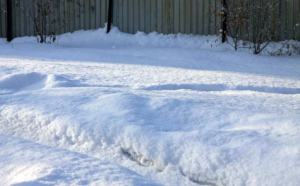 Wiosenny śnieg oświetlony słońcem z śladami — Zdjęcie stockowe