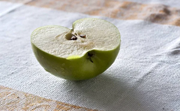 Hälfte des saftigen grünen Apfels auf dem Tisch — Stockfoto