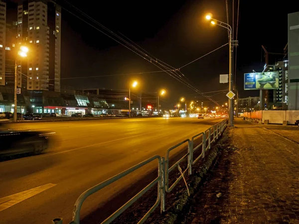 Verlichte straat met bewegende auto 's in de winter nacht — Stockfoto