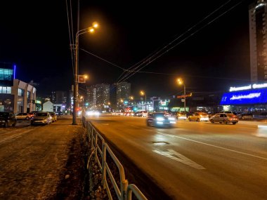 Kış gecesi hareket halindeki arabalarla aydınlatılmış şehir caddesi