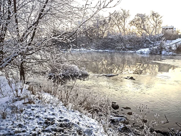 Trees covered with frost near the unfrozen river in winter — ストック写真