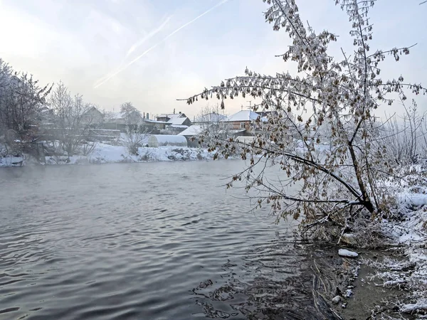 Деревья, покрытые морозом у незамерзшей реки зимой — стоковое фото