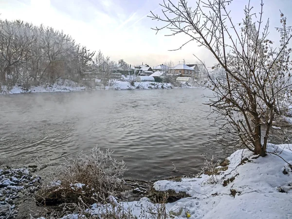 Trees covered with frost near the unfrozen river in winter — ストック写真