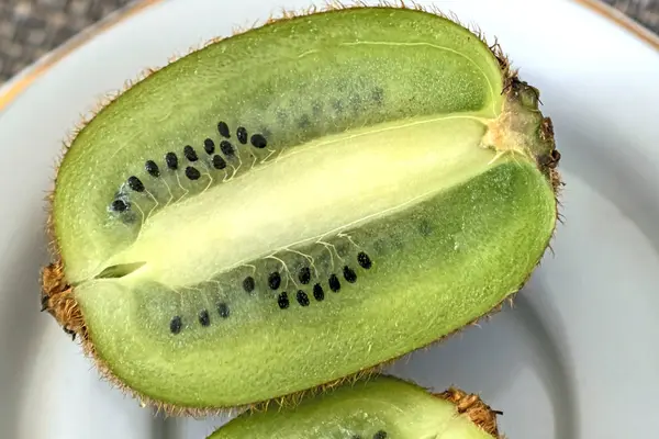 Kiwi-Frucht auf einem Teller halbieren — Stockfoto