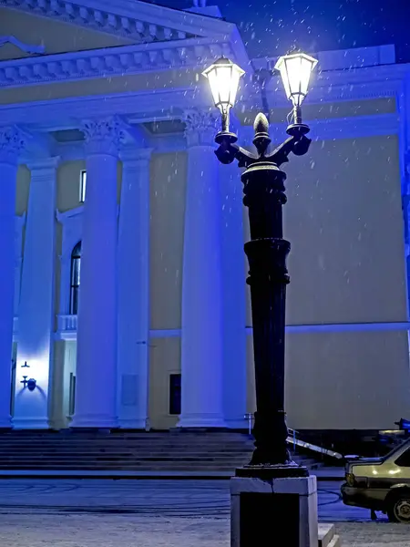 Огни города оформлены в античном стиле в зимнюю ночь во время снегопада возле Оперного театра в Челябинске — стоковое фото